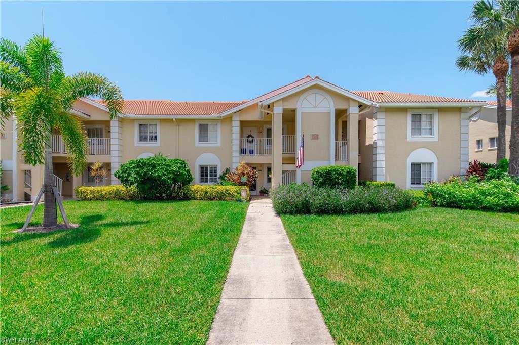 View of front of home with a balcony and a front lawn