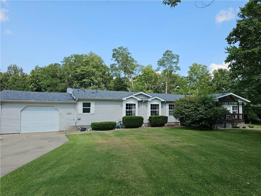 a view of a house with a yard and large trees