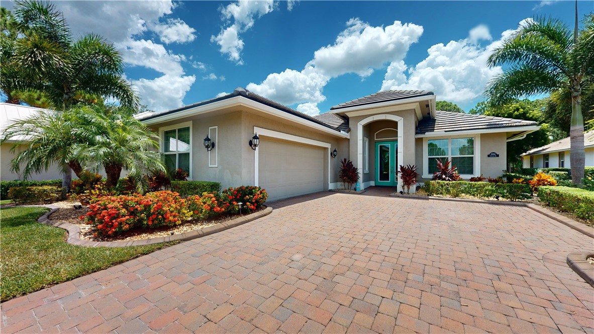 a front view of a house with a yard and a garden