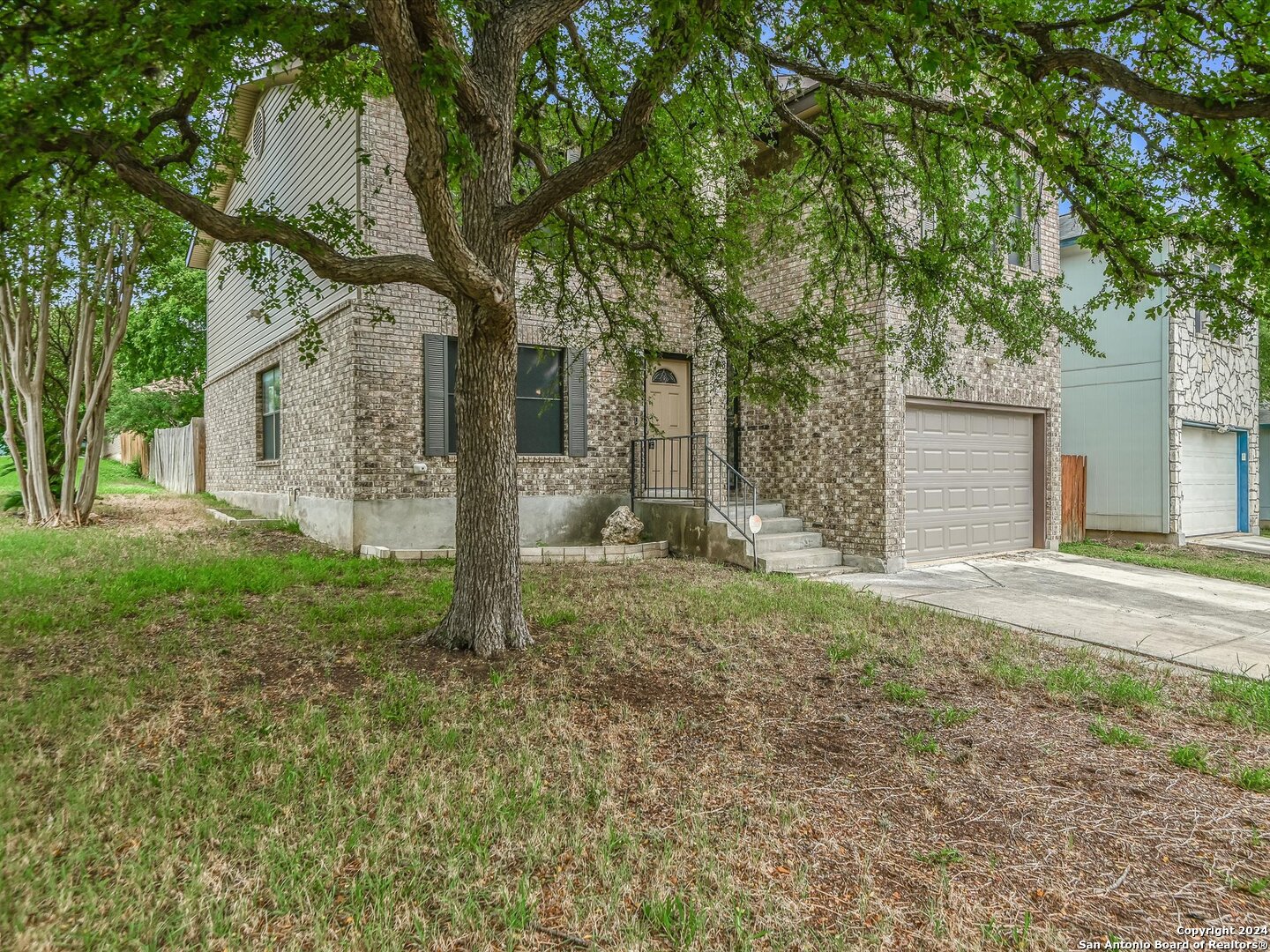 a view of a house with yard and a tree