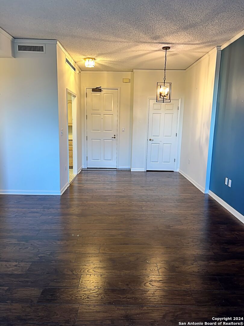 an empty room with wooden floor and window