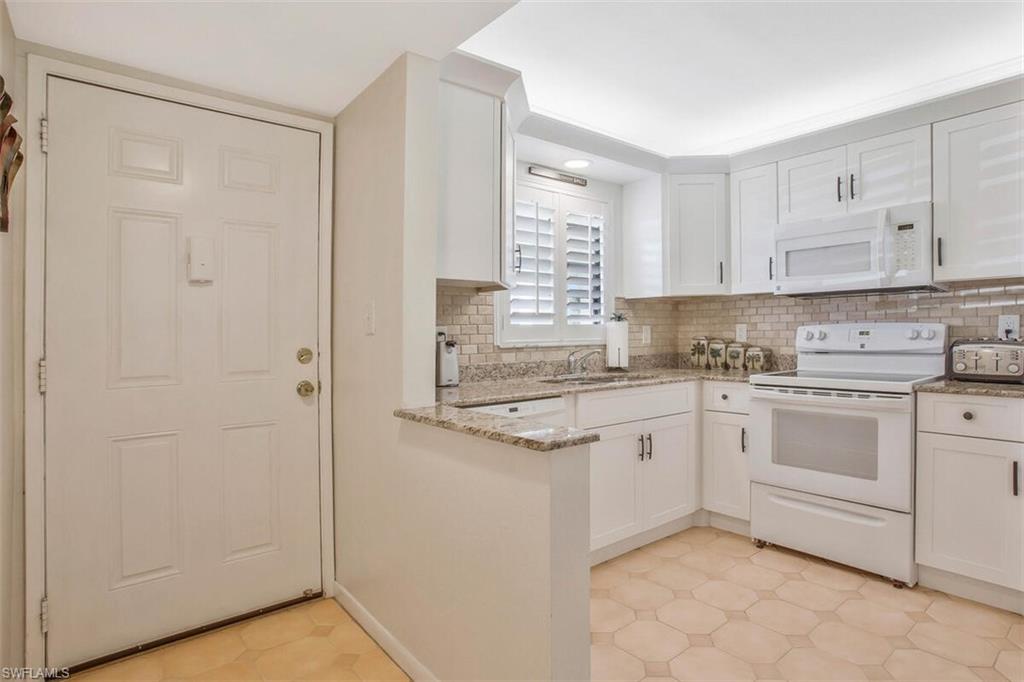 a kitchen with white cabinets and white appliances