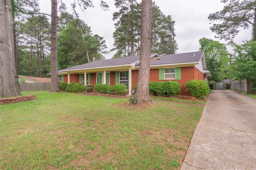 a front view of a house with a yard and trees