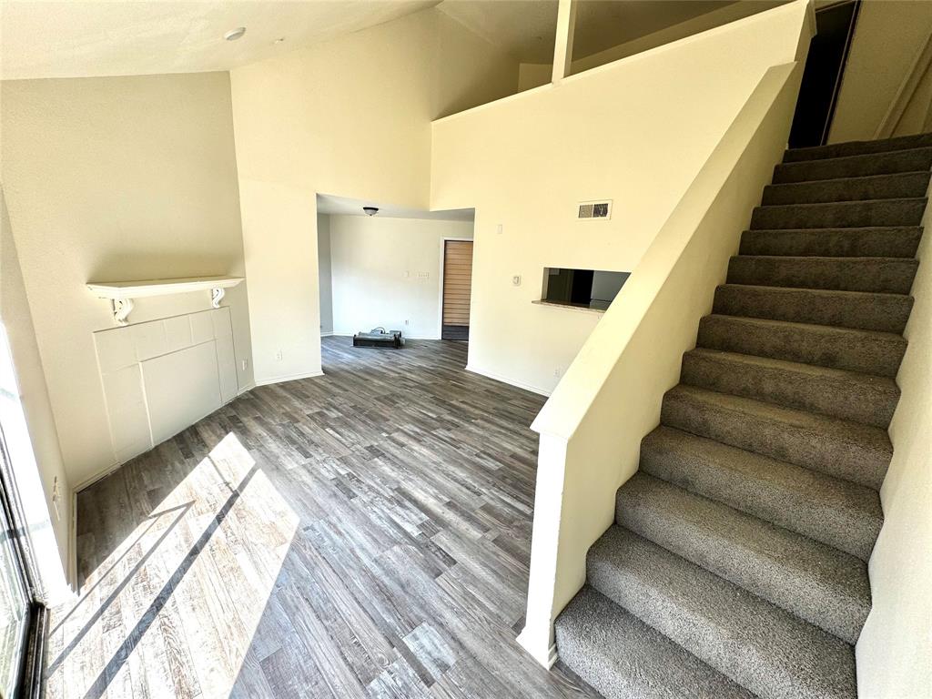 a view of a bedroom with wooden floor and staircase