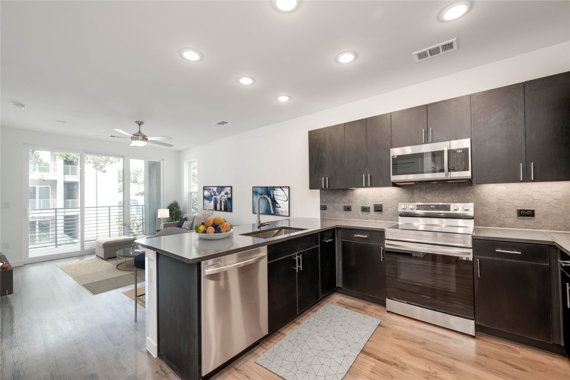 a kitchen with stainless steel appliances granite countertop a stove and a sink