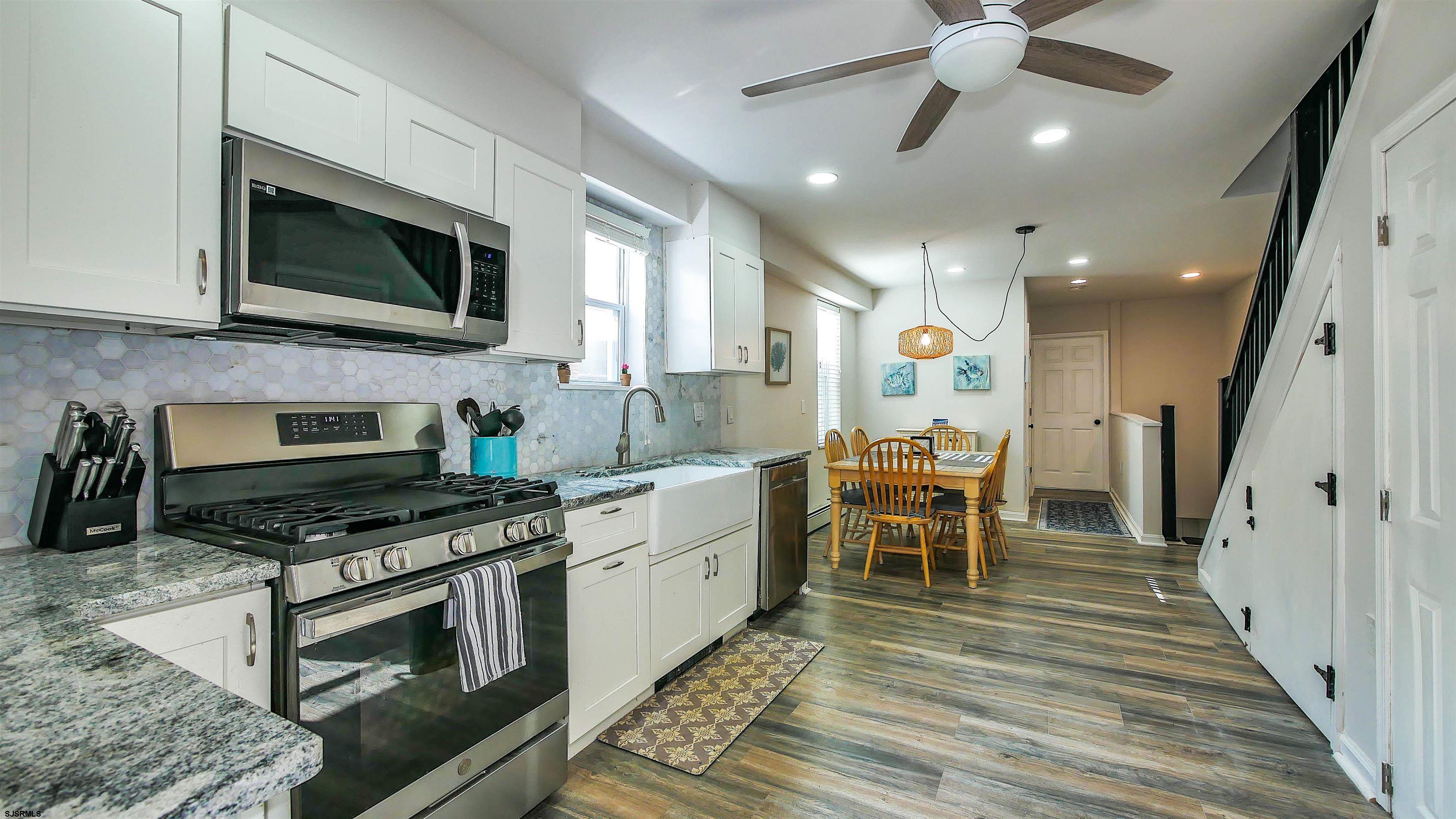 a kitchen with a sink stainless steel appliances and white cabinets