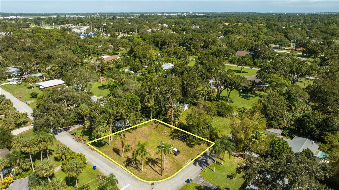 an aerial view of a residential houses with outdoor space and trees