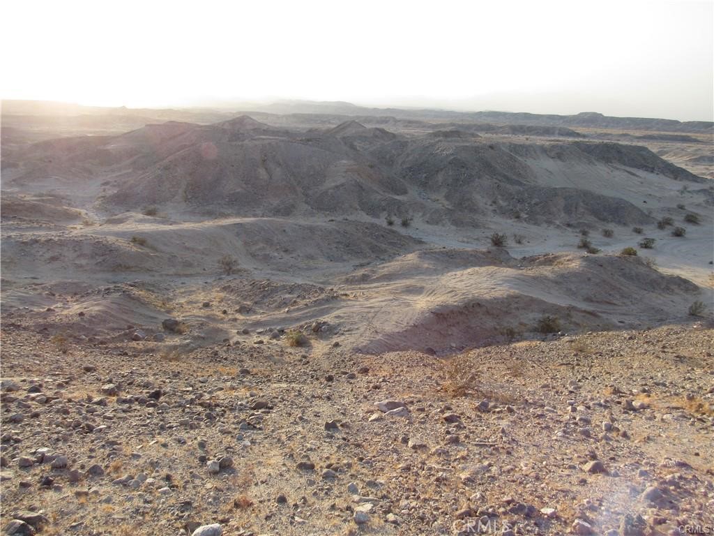 a view of a dry yard with mountains in the background