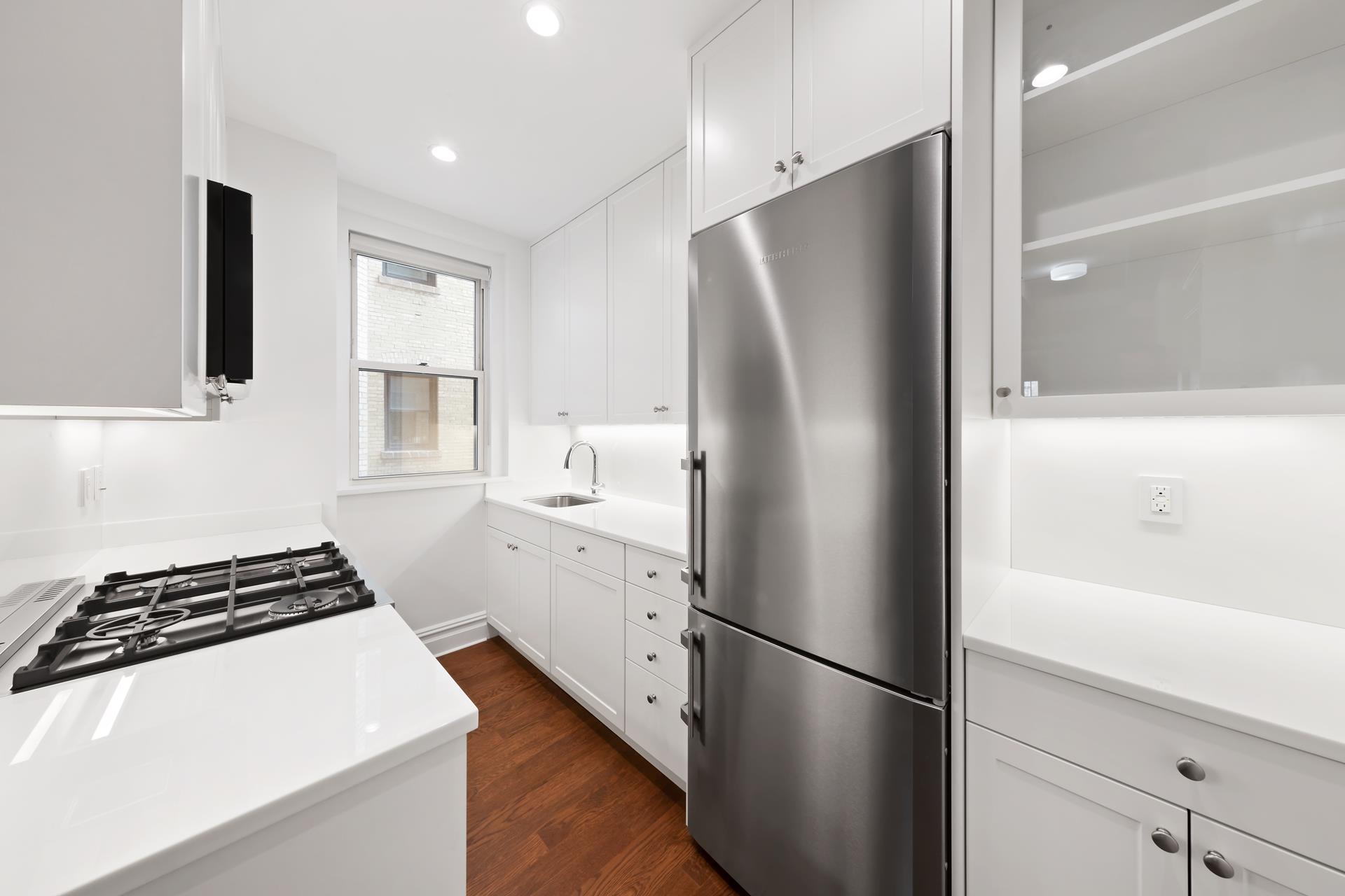 a kitchen with stainless steel appliances a refrigerator sink and cabinets