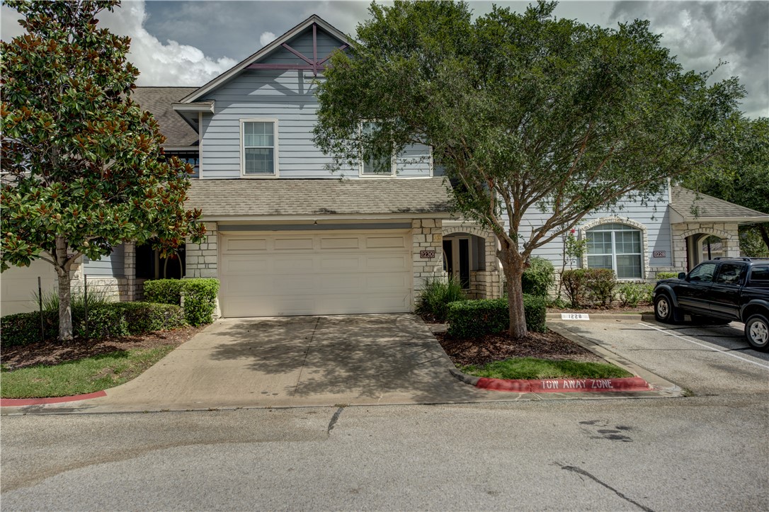 a view of house with outdoor space and parking