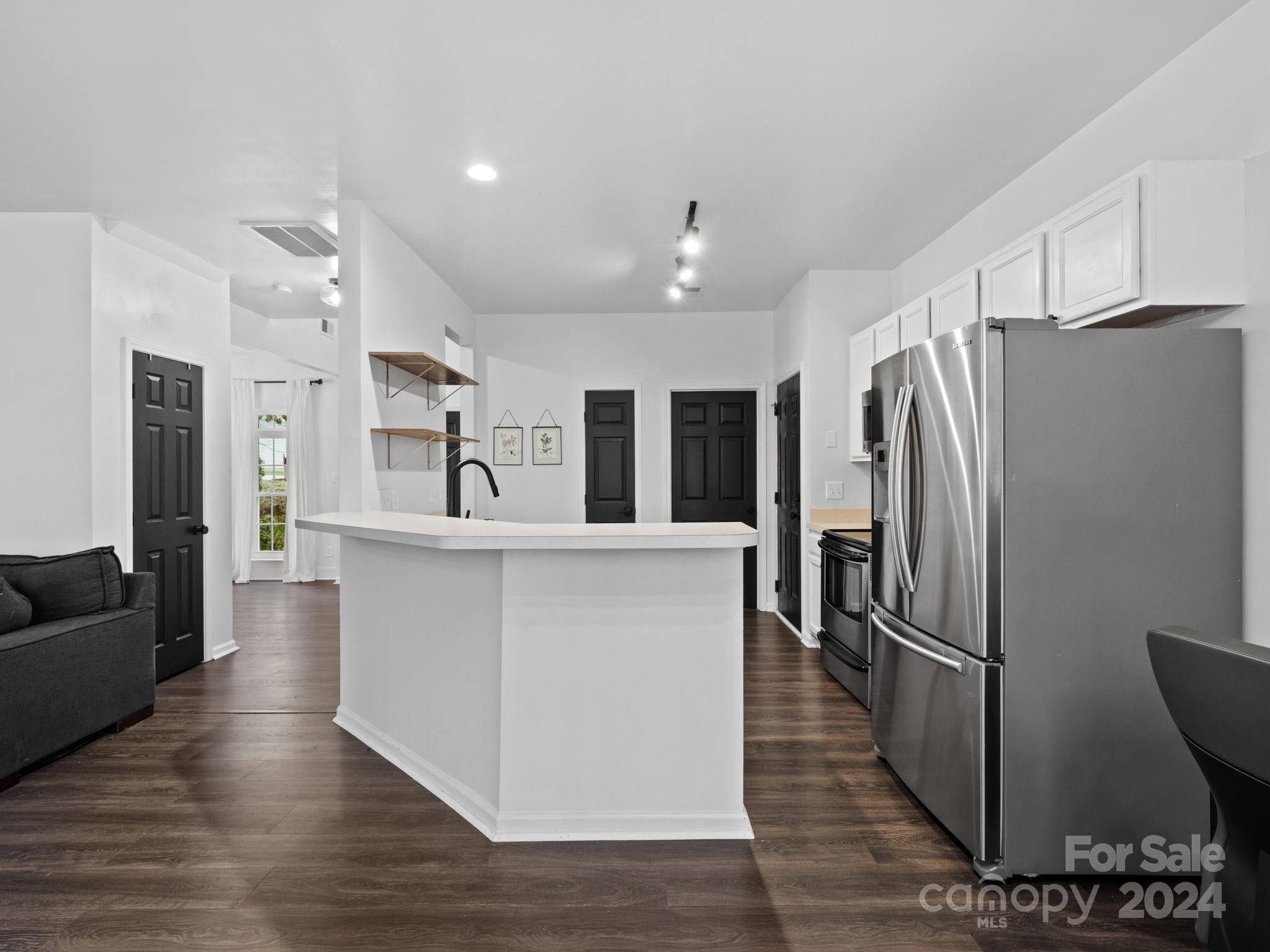 a large kitchen with stainless steel appliances a refrigerator and a stove top oven