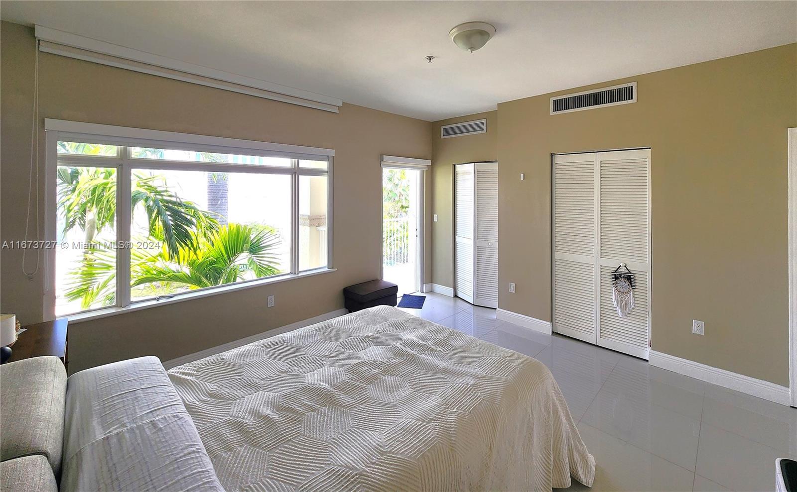 a bedroom with a large bed and a large window