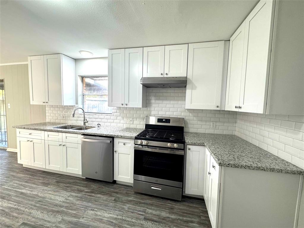 a kitchen with granite countertop a stove a sink and a granite counter tops