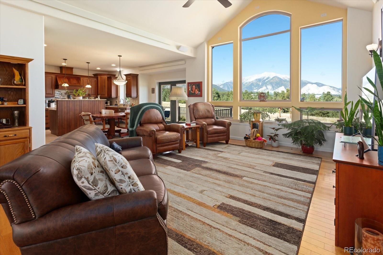 a living room with furniture kitchen view and large windows