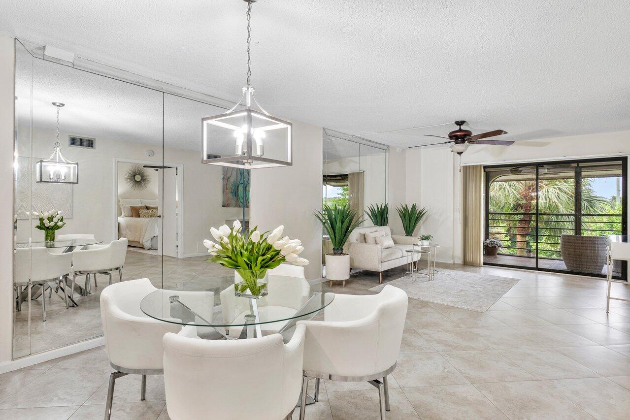 a dining room with furniture a potted plant and a chandelier