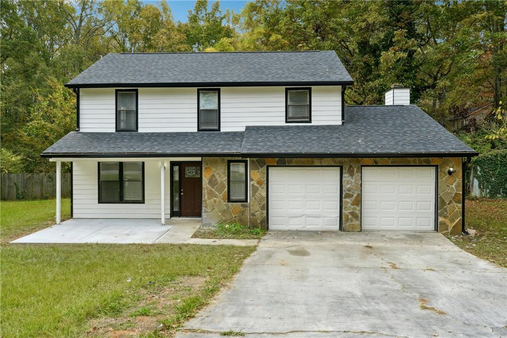 a front view of a house with a yard and garage