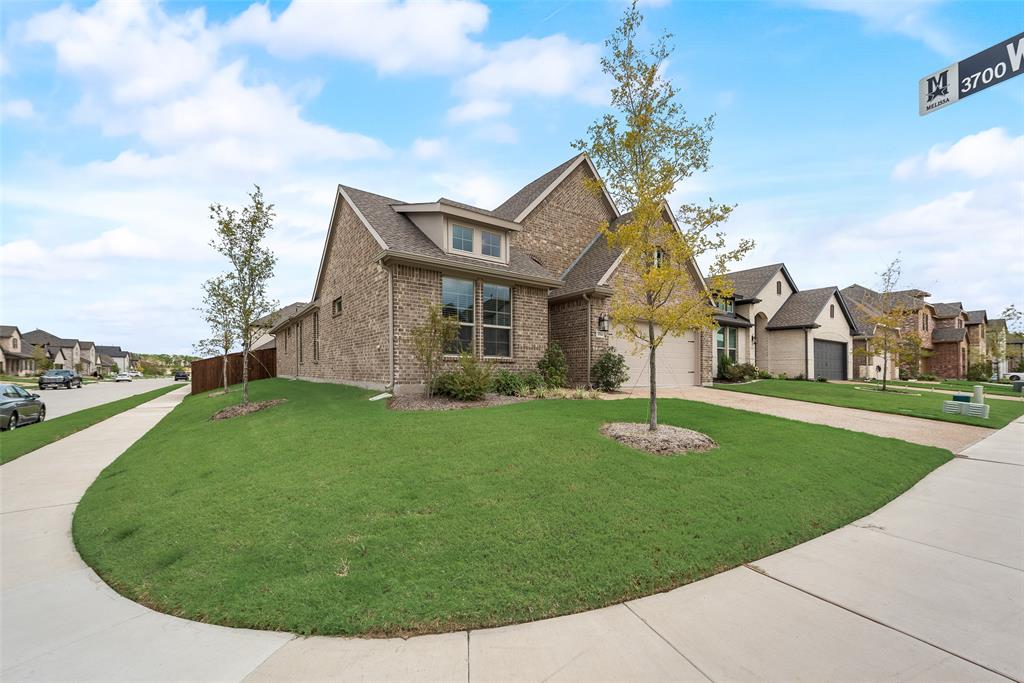 a view of a house with a big yard plants and large trees