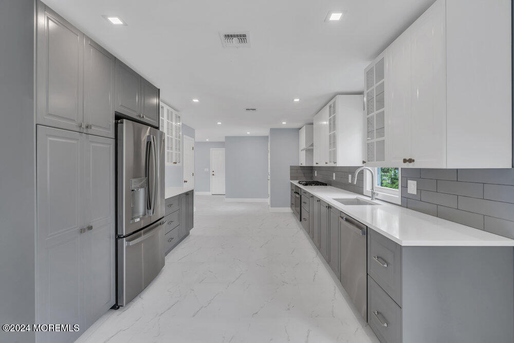 a large kitchen with a refrigerator and a sink