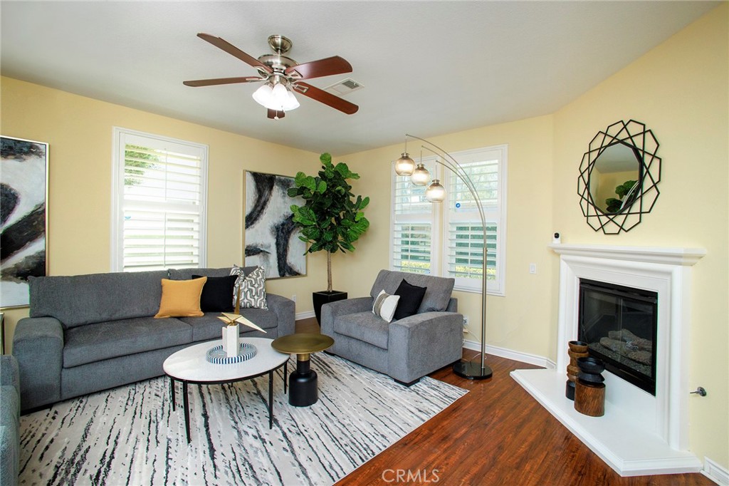 a living room with furniture a fireplace and a large window