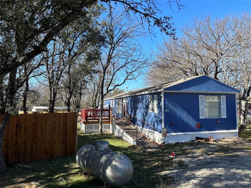 a view of a house with backyard wooden floor and a tree