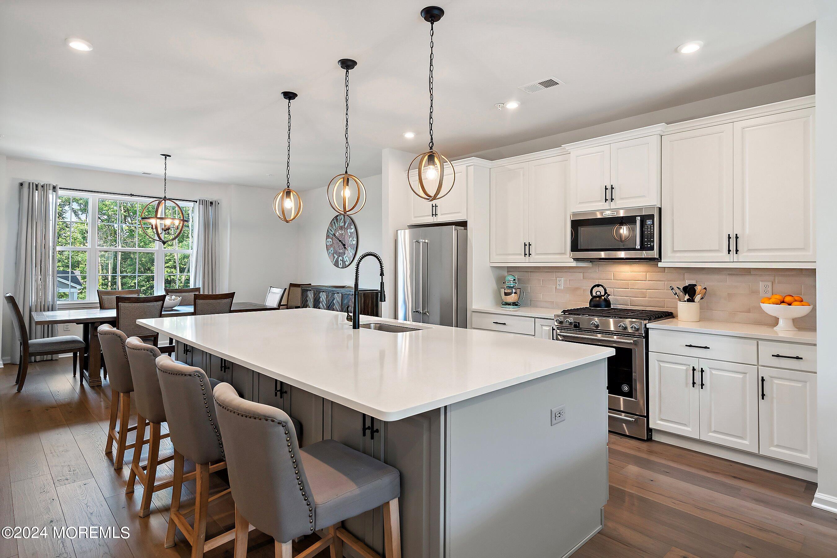 a kitchen with a stove a sink a dining table and chairs