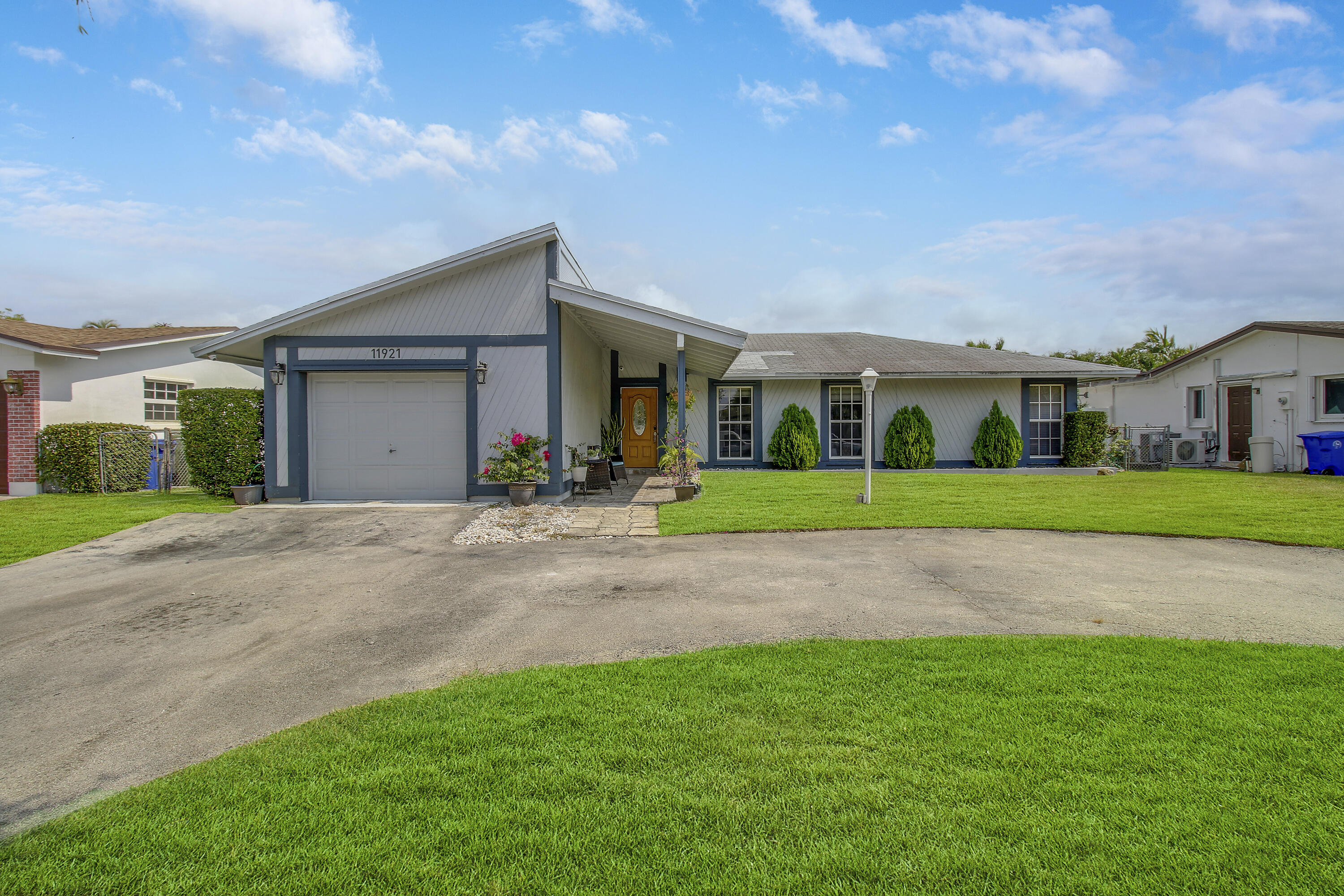 a view of yellow house with a big yard and large trees