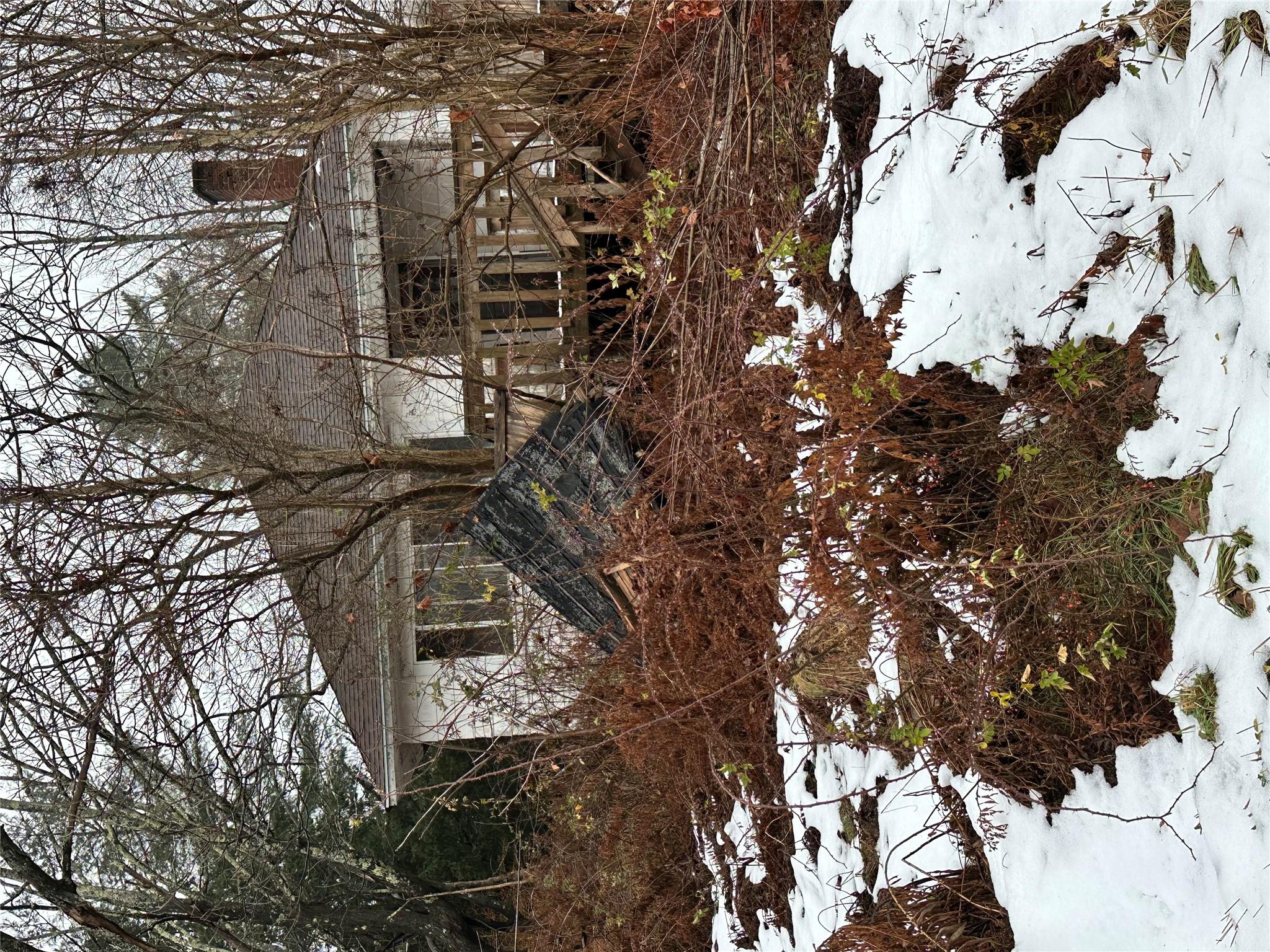 a view of a house with a yard covered in snow