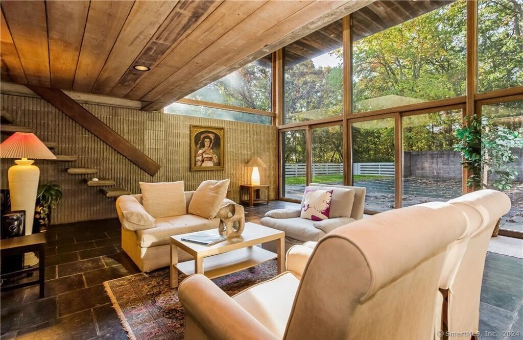 a living room with furniture and a floor to ceiling window