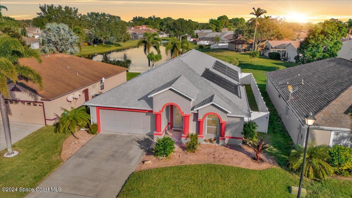 a aerial view of a house with a yard and potted plants