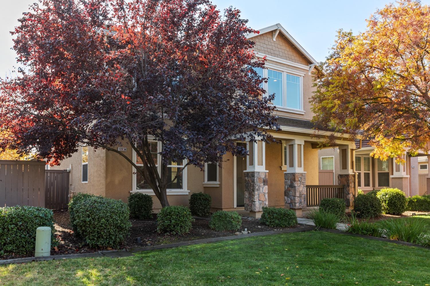 a front view of a house with a yard and trees