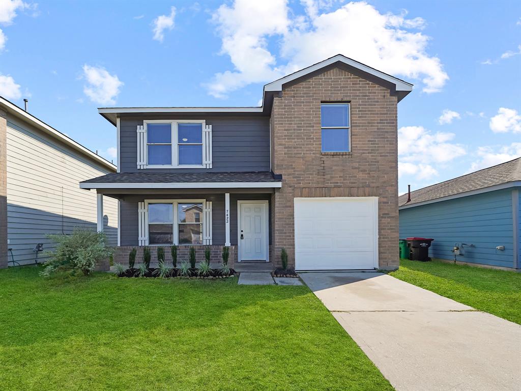 a front view of a house with a yard and garage