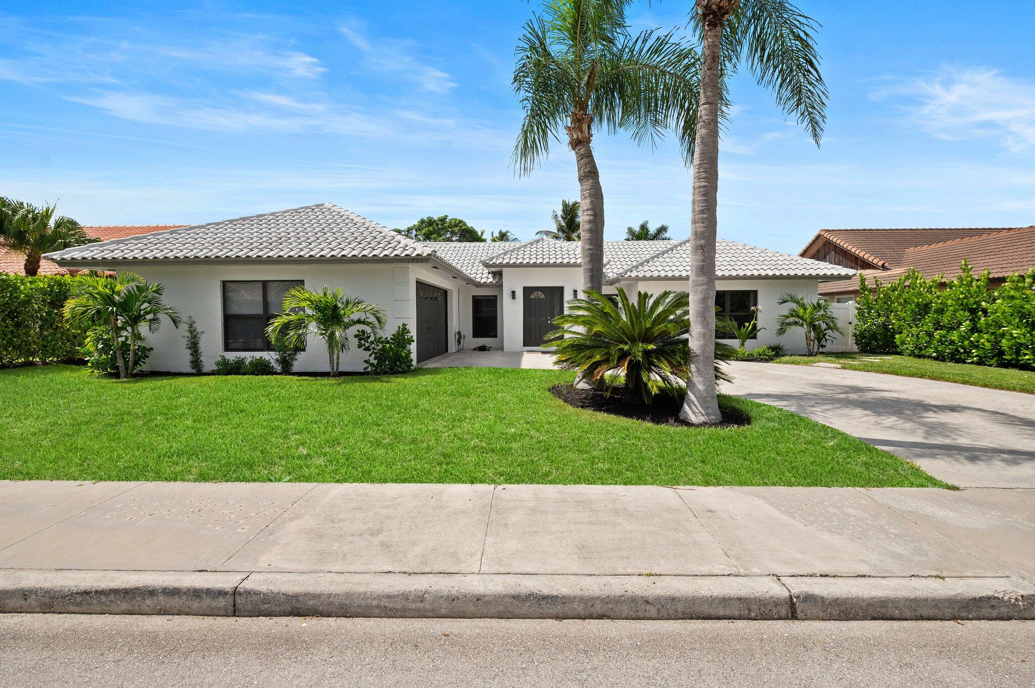 front view of a house with a yard and an trees