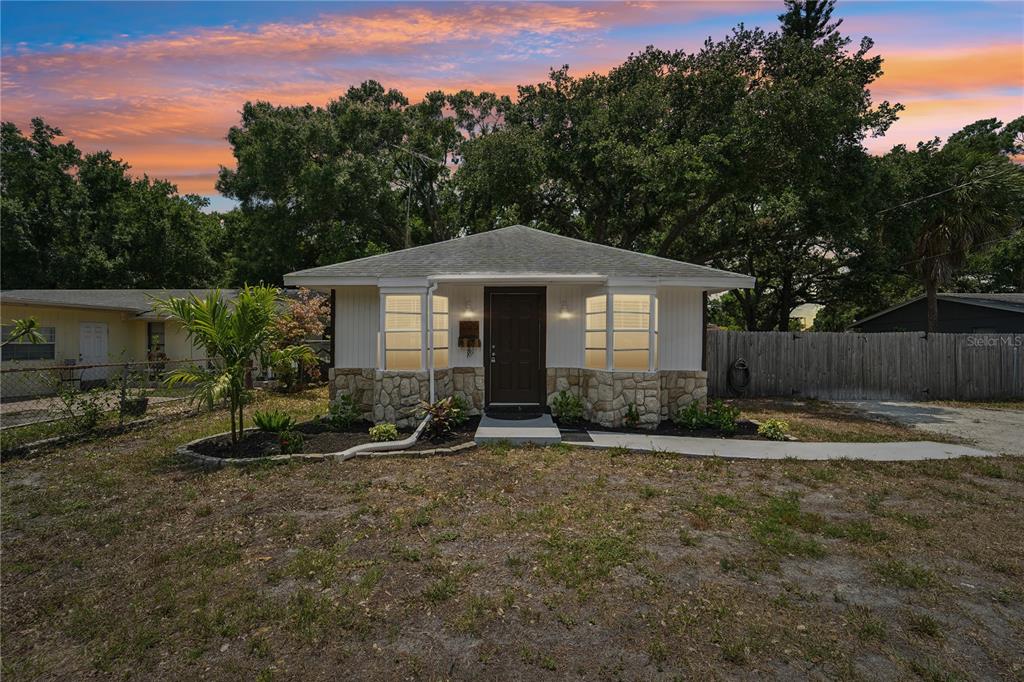 a front view of a house with a yard and trees