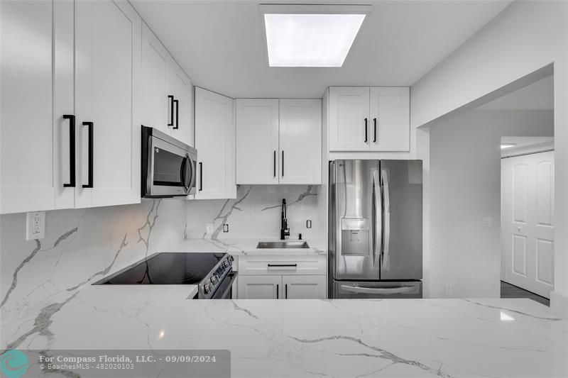 a kitchen with stainless steel appliances a refrigerator sink and microwave