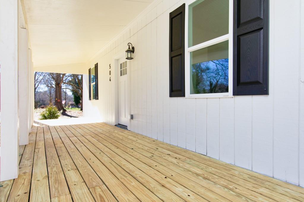 a view of a bedroom with wooden floor and bench