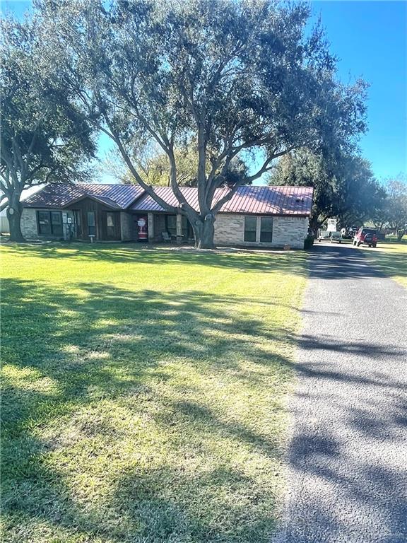 a front view of house with yard and trees in the background