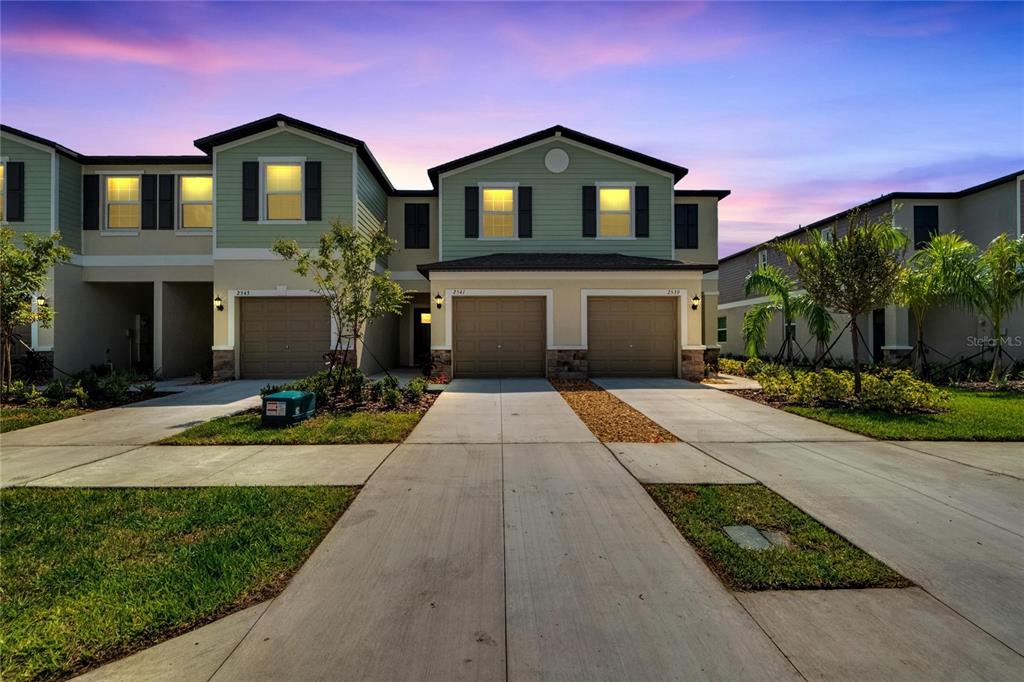 a front view of a house with yard and green space