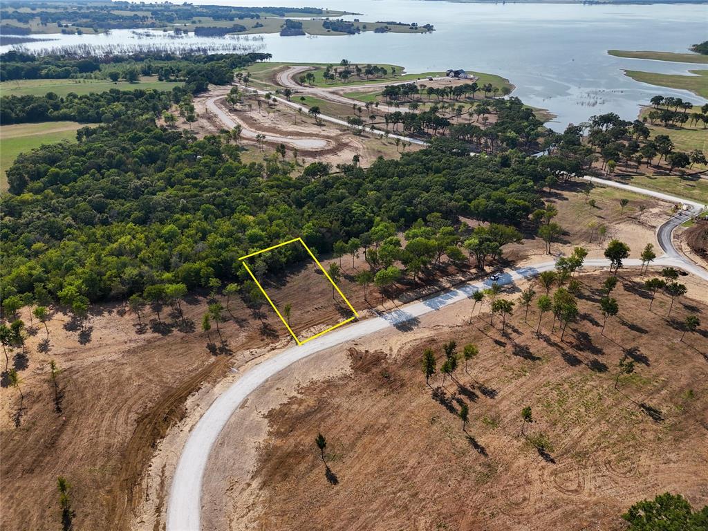 an aerial view of a house with a yard and lake view