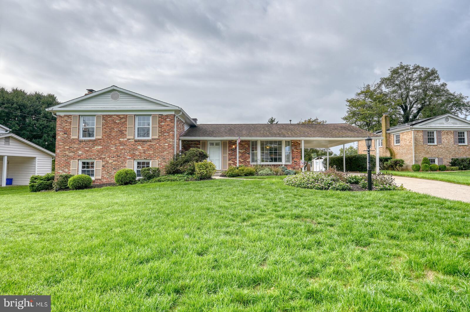 a front view of a house with a yard and green space