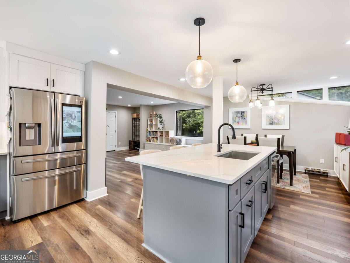 a kitchen with stainless steel appliances kitchen island a island in the center and wooden floor