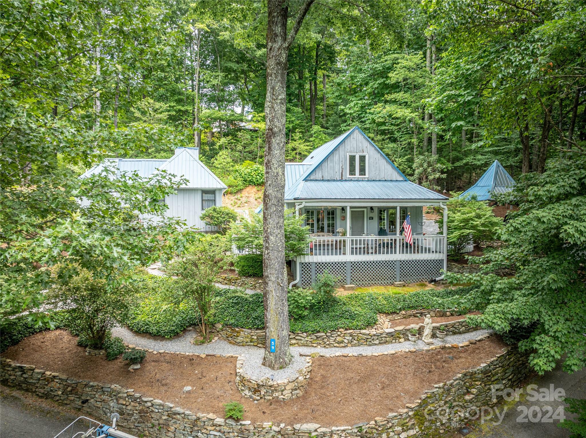 a front view of a house with a yard and potted plants