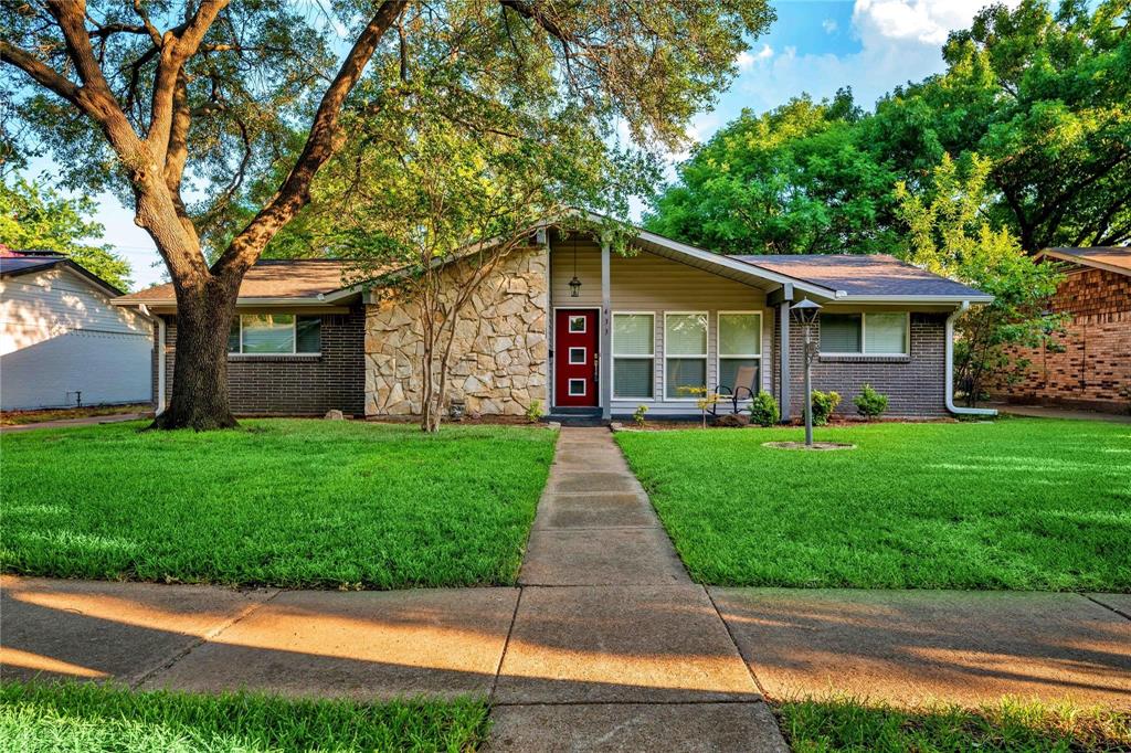 a front view of a house with a yard and green space