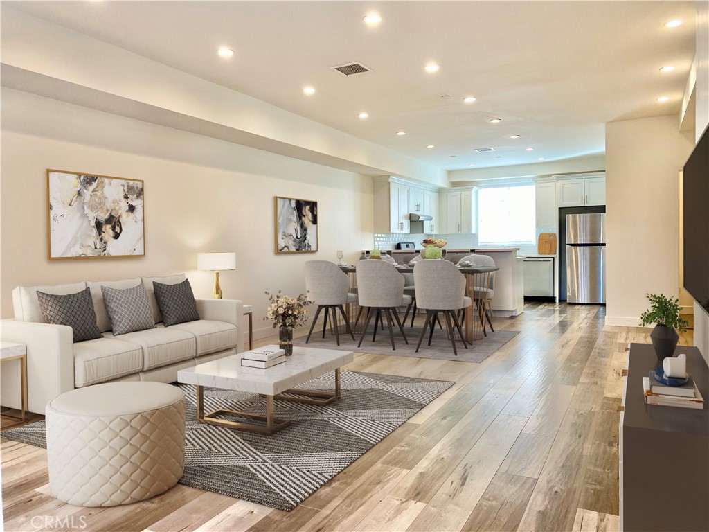 a living room with lots of furniture and kitchen view