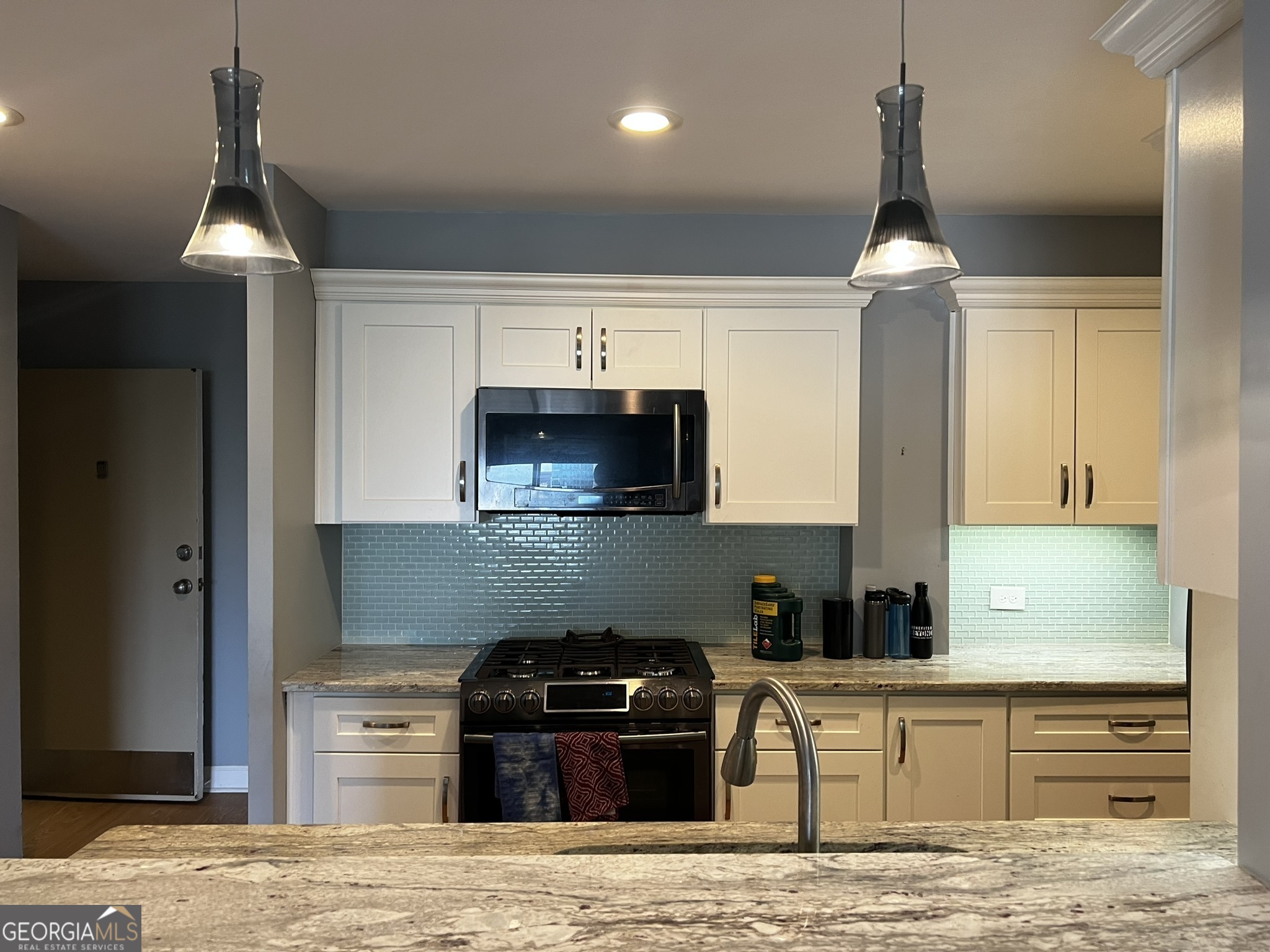 a kitchen with granite countertop a stove and a sink