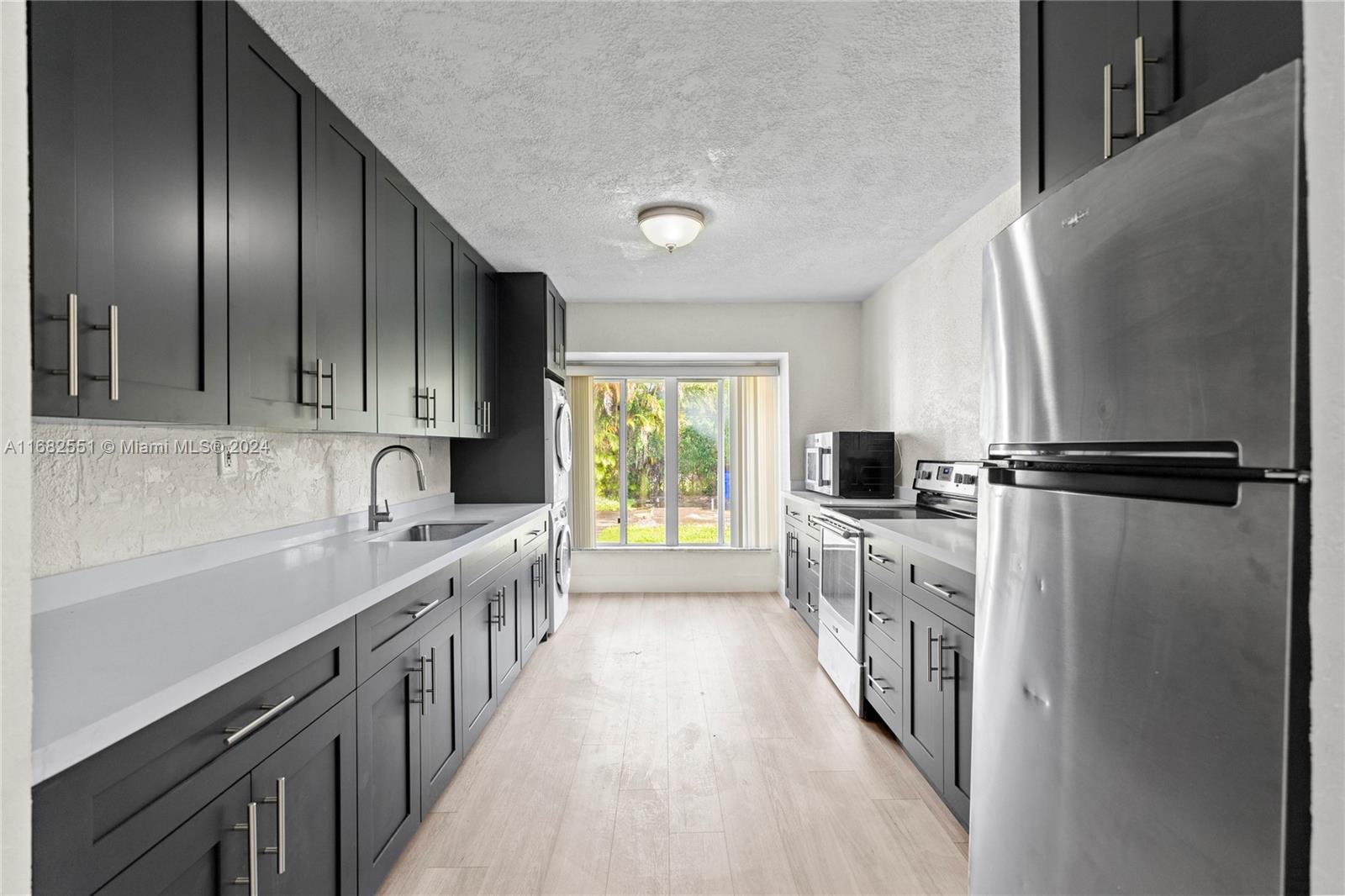 a kitchen with stainless steel appliances granite countertop lots of counter top space and wooden floor