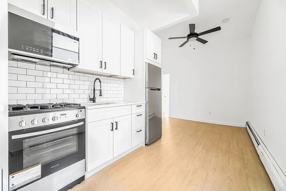 a kitchen with white cabinets and appliances