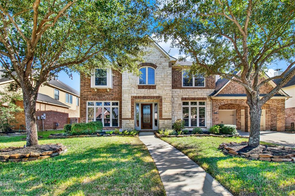 front view of a brick house with a yard