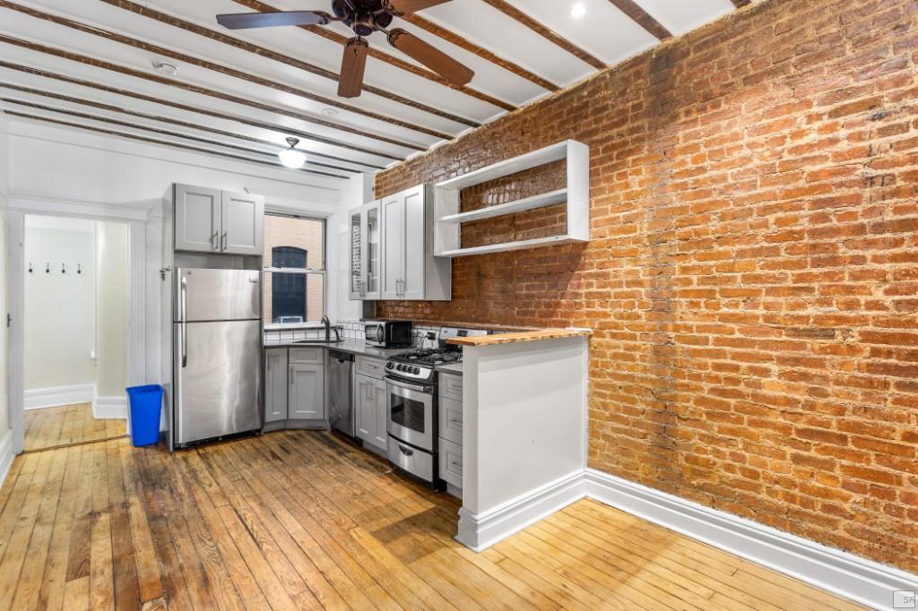 a kitchen with a wooden floor and a refrigerator