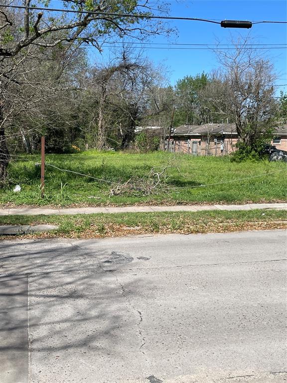 a view of a house with a yard and a large parking space