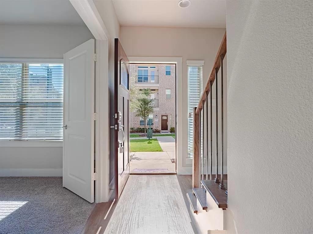 a view of a hallway with wooden floor and a living room